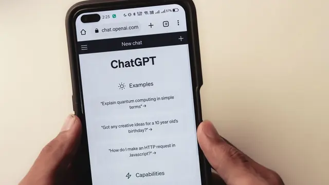 Close-up of a hand holding a smartphone displaying an AI chat interface