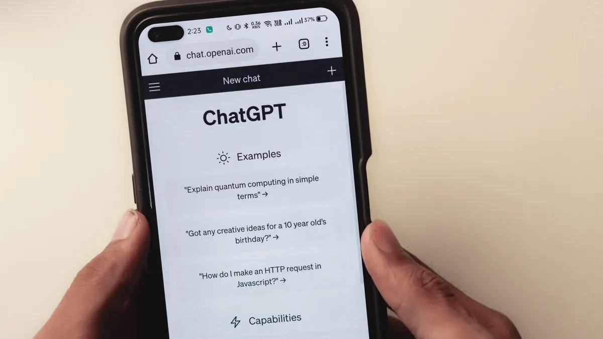 Close-up of a hand holding a smartphone displaying an AI chat interface