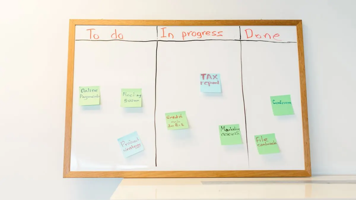 Whiteboard with colored sticky notes organized into planning categories