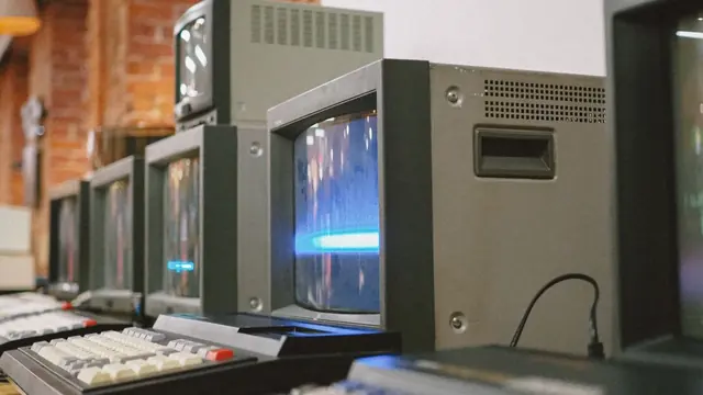 Row of vintage CRT computer monitors representing legacy technology