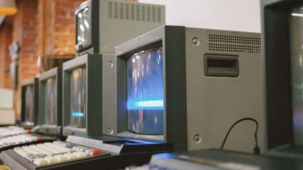 Row of vintage CRT computer monitors representing legacy technology