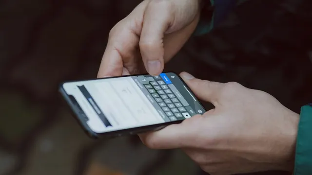 A person typing a search on a smartphone