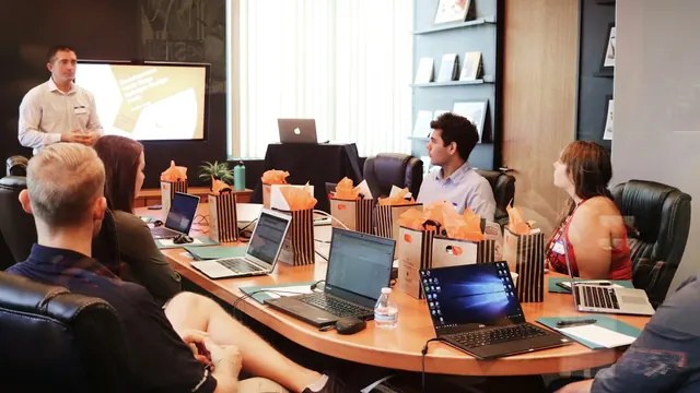 A team in a meeting room listening to a colleague present