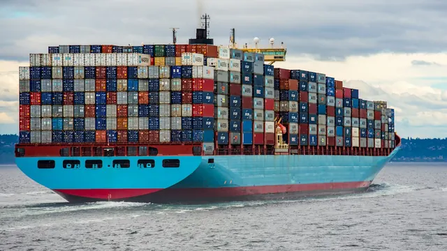 A container ship loaded with stacked containers at sea