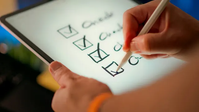 A hand ticking off items on a checklist